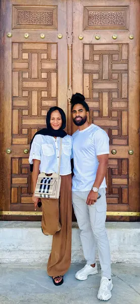 Shaun and Rebekah standing in front of carved wooden doors