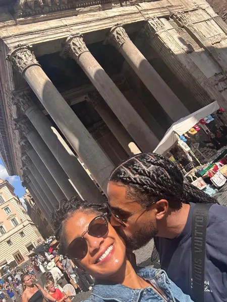 Shaun and Rebekah sharing a kiss near stone columns