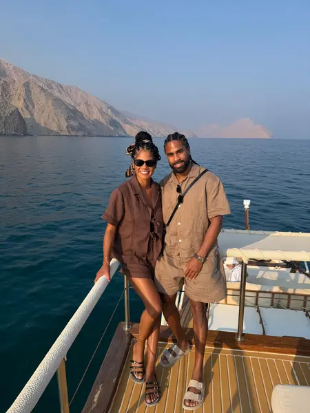 Shaun and Rebekah on a boat with mountains behind them